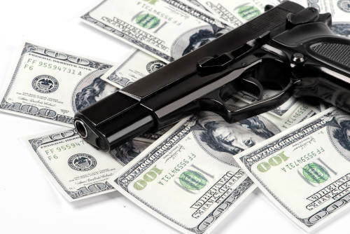 Handgun laying on top of a pile of money